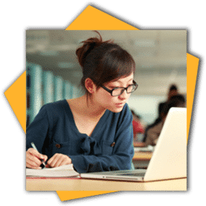 Young woman studying with laptop, writing notes